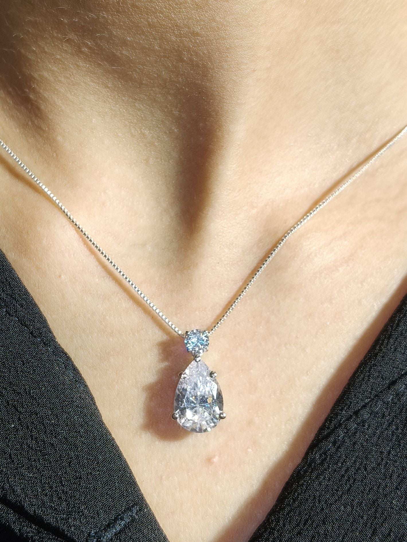 Diamond necklace on a person wearing a black top