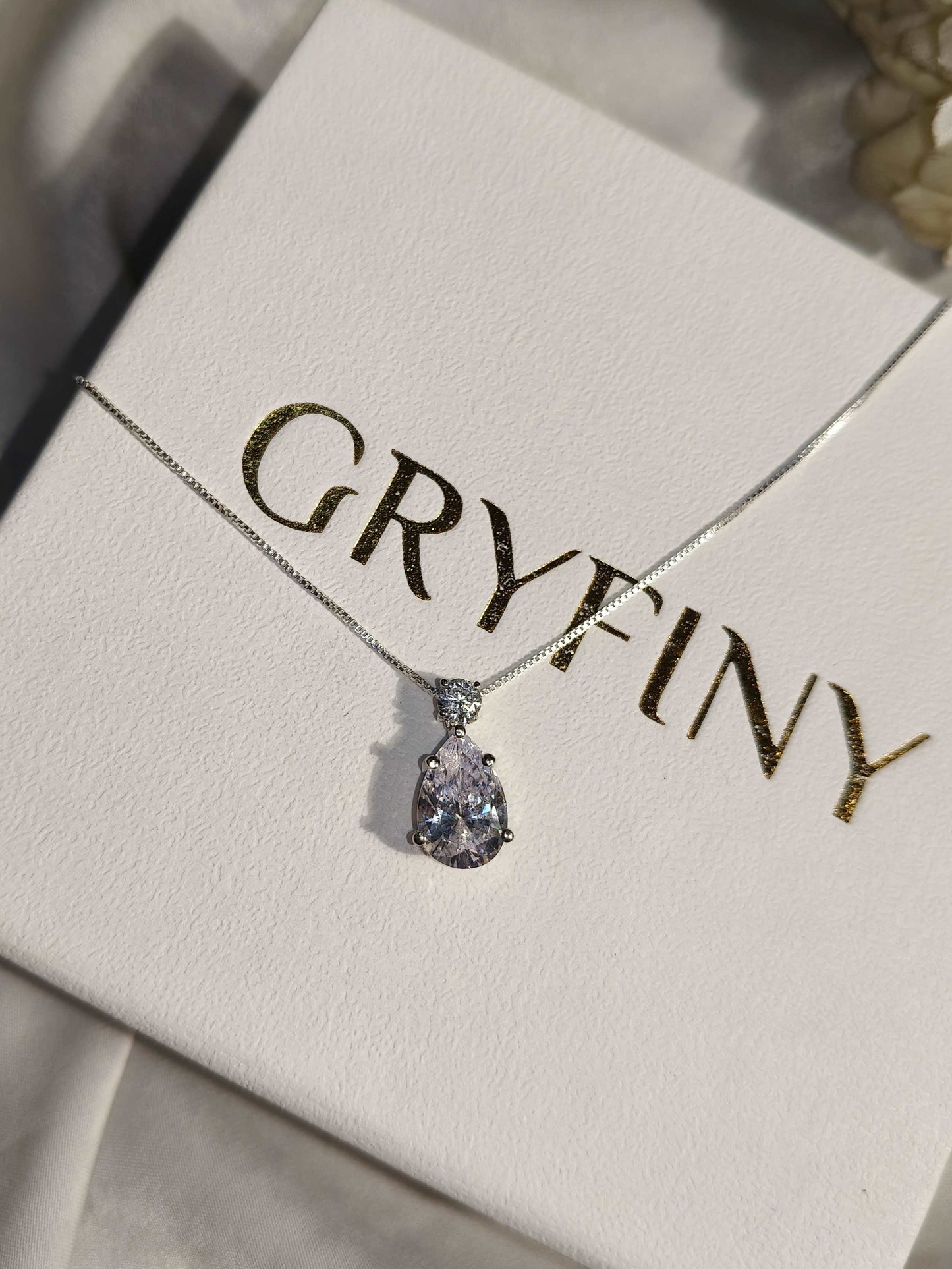 Necklace with a teardrop-shaped pendant on a Gryfiny branded card.